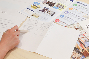 用紙に採用案内の構成図を描く様子